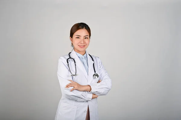 腕を組んで立っている若い自信に満ちた女性医師の肖像画が交差した 白い隔離された背景 — ストック写真