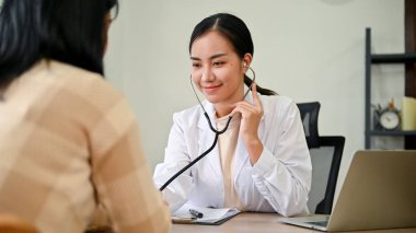 Genç bayan doktor, klinik odasında kadın hastaya teşhis koydu. Sağlık hizmetleri kavramı. 