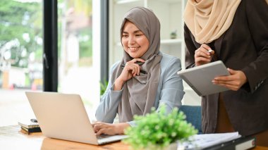 Profesyonel Müslüman iş adamları, ofis odasında önemli bir proje üzerinde tartışıyorlar..