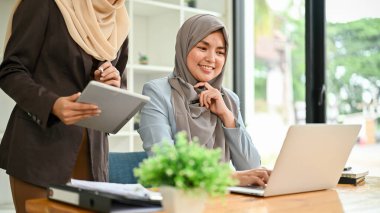 Profesyonel Müslüman iş adamları, ofis odasında önemli bir proje üzerinde tartışıyorlar..