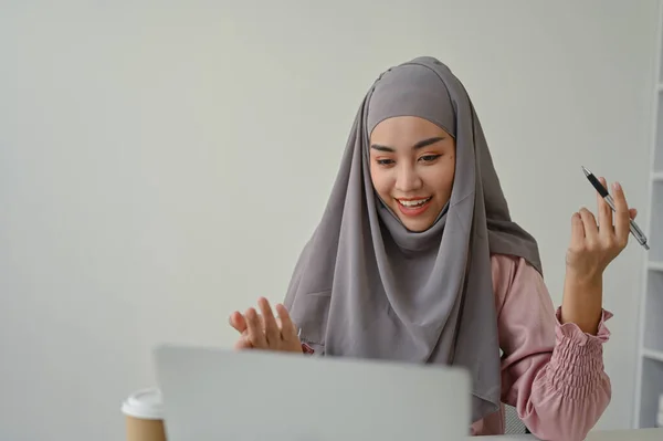 Stock image Young Asian muslim businesswoman having a video conference with her team, sitting in the office room. 