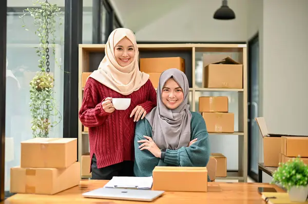 stock image A portrait of a beautiful and successful young Asian Muslim female online sellers are in the office with cardboard boxes. online business, SME, e-commerce business