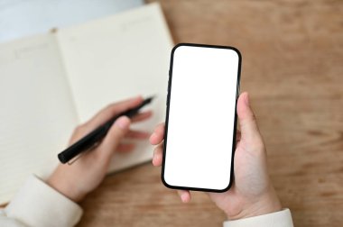 Uzaktan kumandalı bir kafede çalışan bir kadının akıllı telefonunu kullanışının en üst görüntüsü. akıllı telefon beyaz ekran modeli