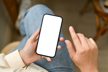 Kafedeki bir masada otururken akıllı telefonunu kullanan genç bir Asyalı kadının yakın plan görüntüsü. akıllı telefon beyaz ekran modeli