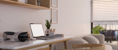 Laptopun beyaz ekran modeli, modern bir VR kulaklık ve minimalist, rahat bir oturma odasındaki masada duran aksesuarlar. 3d görüntüleme, 3d illüstrasyon