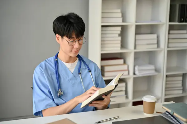 Ένας Έξυπνος Και Συγκεντρωμένος Νεαρός Ασιάτης Φοιτητής Ιατρικής Ποδιά Διαβάζει — Φωτογραφία Αρχείου