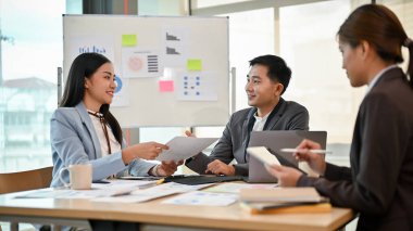 Başarılı ve profesyonel bir Asyalı erkek patron yeni bir proje planlamak için pazarlama ekibiyle toplantıda. Takım çalışması, işbirliği, beyin fırtınası.