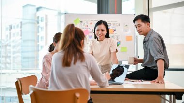 Profesyonel bir Asyalı teknoloji geliştirici ekibi toplantıda, yeni bir mobil uygulama üzerinde tartışıyorlar, planlıyorlar ve beyin fırtınası yapıyorlar. Teknoloji firması konsepti