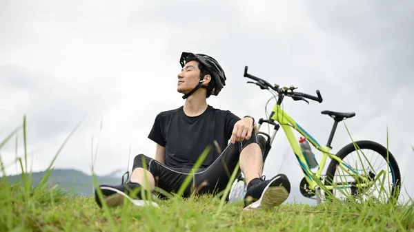 Happy Sporty Young Asian Man Sitting Grass Taking Deep Breath — Stock Photo, Image