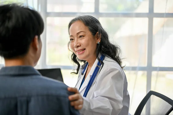 在医院进行体格检查时 一位善良 关心他人的亚洲老年女医生摸着病人的肩膀安慰病人 — 图库照片