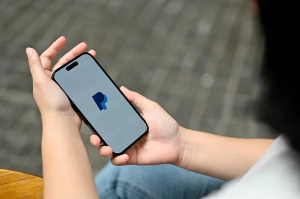 stock image Chiang Mai, Thailand - Jul 11 2023: Close-up image of a female using PayPal application while relaxing outdoors.