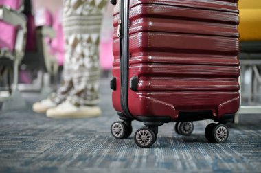 Uçak koridorundaki kırmızı bavulun yakın plan görüntüsü. yolculuk, yolculuk, tatil, ulaşım, uçak