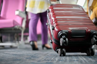 Bir kadın yolcunun uçak koridorunda bavul taşıdığı yakın plan görüntüsü. Uçuş, varış, yolculuk, ulaşım