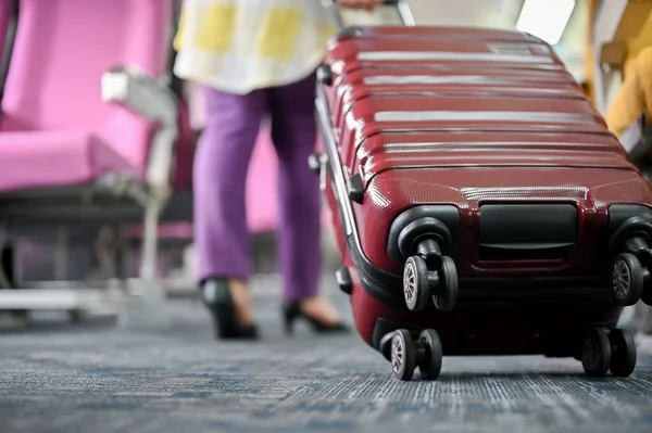 Bir kadın yolcunun uçak koridorunda bavul taşıdığı yakın plan görüntüsü. Uçuş, varış, yolculuk, ulaşım