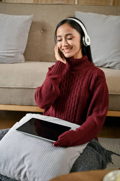 스웨터 매력적 아시아 여인의 사진은 겨울에 거실에서 휴식을 취하면서 헤드폰 — 스톡 사진