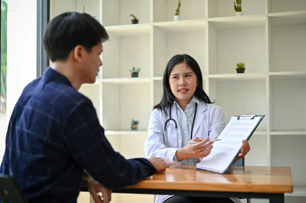 一名专业而严肃的亚洲女医生与一名病人在检查室接受体格检查和医疗咨询 — 图库照片