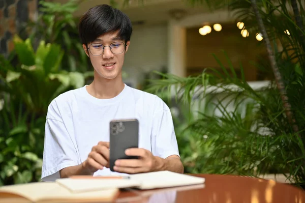 아시아 청년의 사진은 스마트폰을 사용하거나 친구들 수다를 지역의 카페에 미디어를 — 스톡 사진