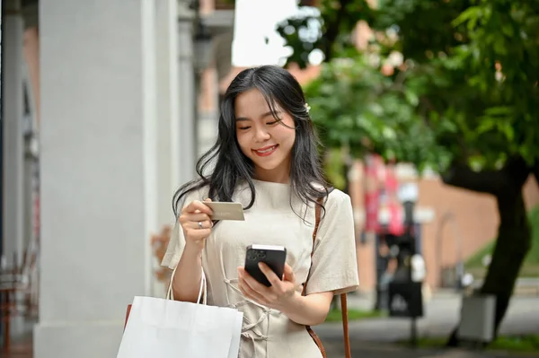 Beautiful Young Asian Woman Looking Her Credit Card Her Smartphone — Stock Fotó