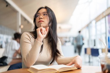 Zeki ve düşünceli genç bir Asyalı kız üniversite öğrencisi kütüphanede bir kitap okuyup araştırma yaparken projesini düşünüyor ve planlıyor..
