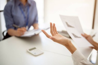 Profesyonel bir iş adamının kadın bir meslektaşıyla toplantıda konuşurken ve tartışırken çekilmiş yakın plan görüntüleri..