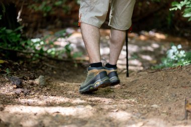 Asya 'lı bir erkek yürüyüşçünün ya da yürüyüşçünün dağda yürüyüş yaparken güzel ve yeşil doğanın tadını çıkarırken yakın plan görüntüsü..