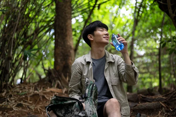 Een Ontspannen Vrolijke Aziatische Mannelijke Wandelaar Trekker Zit Drinkt Water — Stockfoto