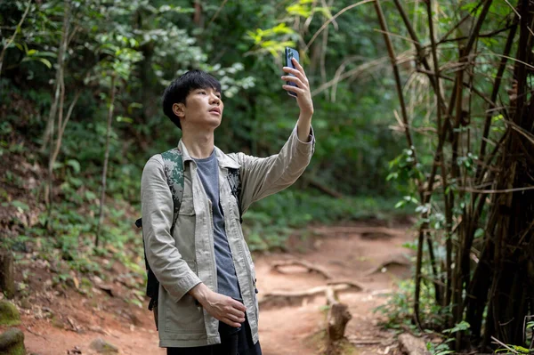 Een Verwarde Serieuze Aziatische Mannelijke Reiziger Die Zijn Smartphone Vasthoudt — Stockfoto