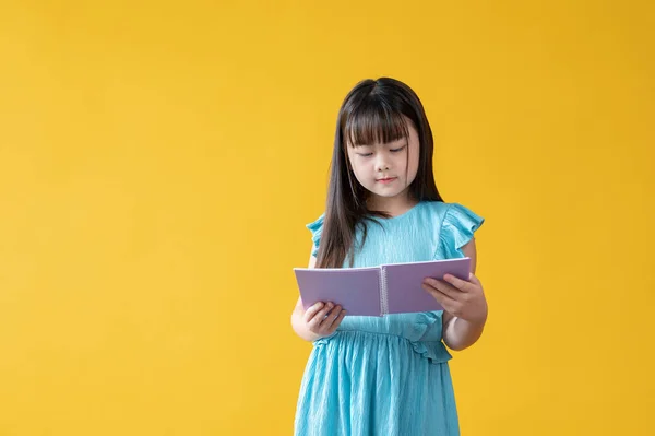 Ein Süßes Kleines Asiatisches Mädchen Einem Hübschen Blauen Kleid Liest — Stockfoto