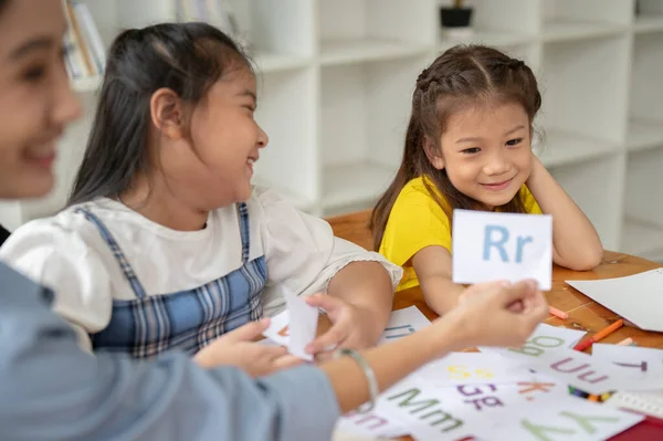 Två Bedårande Unga Asiatiska Flickor Njuter Att Studera Engelska Alfabetskort — Stockfoto