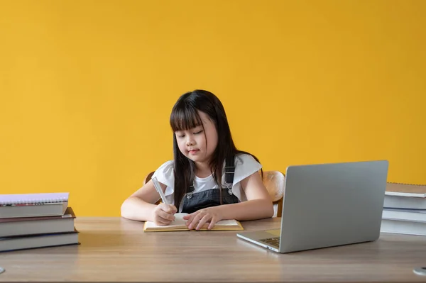一个可爱的年轻亚洲女孩正在一个孤立的黄色背景下在她的学习桌上做作业 Study Learn Education Knowledge School Kindergarten Primary School Student — 图库照片