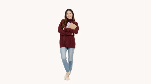 赤いセーターの美しいアジアの若い女性は 孤立した白い背景に立っている間 カメラに本と微笑みを抱いています 大学生 高校生 教育コンセプト — ストック写真
