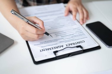 Masada kontrat imzalayan bir kadının yakın plan fotoğrafı. Yasal, finansal sözleşme, evraklar