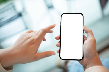 Arka planda bulanık bir kafe üzerinde beyaz ekran modeli olan akıllı telefonu tutan bir kadının yakın plan görüntüsü..