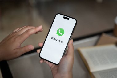 Chiang Mai, Tayland - 14 Ağustos 2023 iPhone 14 'ünde WhatsApp kullanan bir kadın. iPhone 14 'ün ekranındaki WhatsApp logosunun yakın plan görüntüsü.