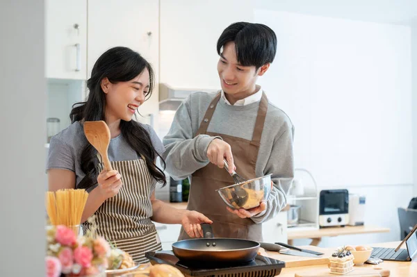 素敵でかわいい若いアジアのカップルは一緒にキッチンでパンケーキを作って楽しんで 一緒に食事を作っている — ストック写真