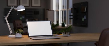 Laptop beyaz ekran modeli, masa lambası, saksı çiçeği, gözlük ve geceleri modern bir odada kitap olan ahşap bir masa. Gece konseptinde çalışma alanı. 3d görüntüleme, 3d illüstrasyon