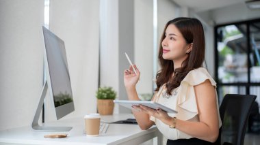 Güzel bir Asyalı iş kadını bir proje düşünüyor, kafasında bir iş planlıyor, ya da masasında elinde tabletle otururken başarılı kariyerini hayal ediyor..