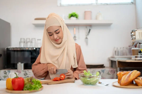 ヒジャブの魅力的なアジアのイスラム教徒の女性や主婦は 自宅で彼女の健康的な食事を作るキッチンで食べ物を準備しています — ストック写真