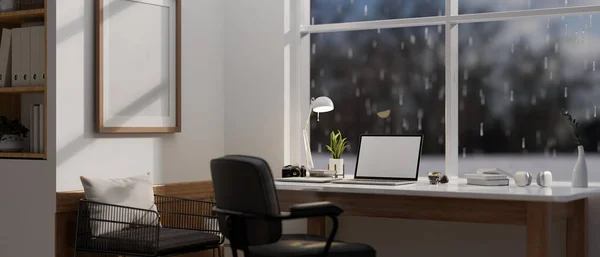Modern, minimal home office workspace with a laptop white screen mockup on a table against the window on a rainy day. 3d render, 3d illustration