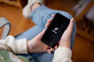 Chiang Mai, Tayland - Sep 06 2023: Ekranda TikTok logosu olan iPhone 14 tutan bir kadının yakın plan görüntüsü. TikTok logosu. iPhone 14 'ünde TikTok uygulaması kullanan bir kadın.