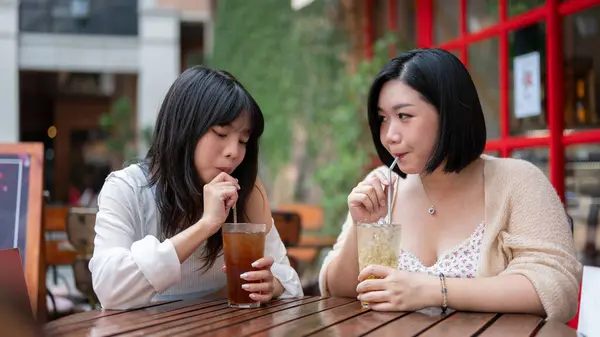 Two Happy Pretty Asian Female Friends Enjoying Drink While Sitting — Stock Photo, Image