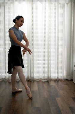 Taytlı ve taytlı genç zarif balerin evinde performans için yeni hareketler deniyor. bale konsepti.