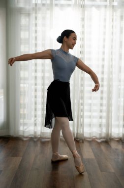 Taytlı ve taytlı genç zarif balerin evinde performans için yeni hareketler deniyor. bale konsepti.