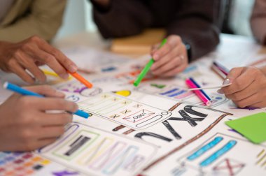 Toplantı odasında genç profesyonel UX UI tasarımcılarının projeleriyle ilgili tartışmalarına yakından bakın. UX UI kavramı.