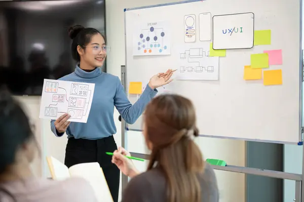 stock image Young smart UX UI designer presenting her idea to the team, presentation during the team meeting. UX UI concept