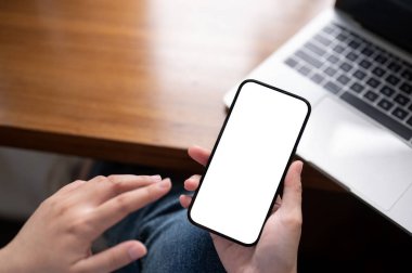 Ofis masasında akıllı telefonunu kullanan bir kadının yakın plan görüntüsü. Bir kadının elindeki beyaz ekran akıllı telefon modeli..