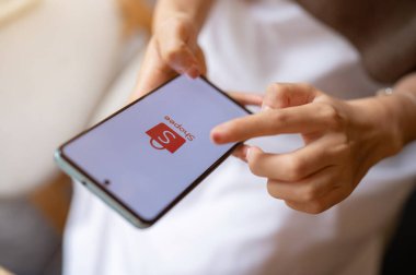 Chiang Mai, Tayland - 12 Ekim 2023 Bir kadın bir kafede dinlenirken akıllı telefonunda Shopee kullanıyor. iPhone 14 'te Shopee logosu. İnternetten alışveriş, e-ticaret platformu