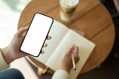 Bir kadının günlüğünü tutarken akıllı telefonunu kullanırken ya da bir kafede kitabına bir şeyler yazarken en iyi görüntüsü. Grafik reklamlarınızı göstermek için beyaz ekran akıllı telefon modeliName