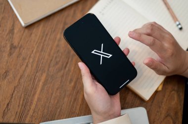 Chiang Mai, Tayland - 18 Ekim 2023: Masasında X Twitter platformunu kullanan bir kadının yakın plan görüntüsü. Sosyal medya platformu kavramı