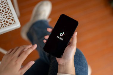 Chiang Mai, Tayland - 19 Ekim 2023: TikTok uygulamasını kullanan ya da Iphone14 'teki TikTok hesabına giriş yapan bir kadının yakın plan resmi. Sosyal medya platformu kavramı